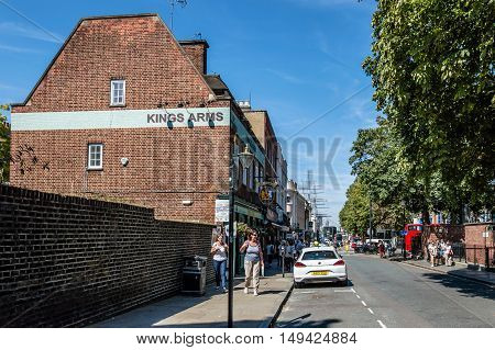 LONDON UK - AUGUST 22 2015: The streets of Greenwich with cutty sark on background a sunny day of summer with tourists walking on.