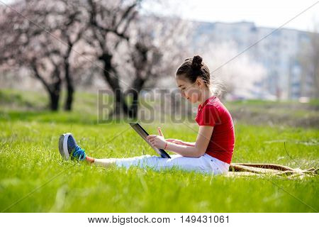 kid hold tablet phone for playing and education. Little girl Using a Tablet closeup. a girl with the tablet on the nature