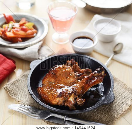 pork steak in a frying pan, fried vegetables
