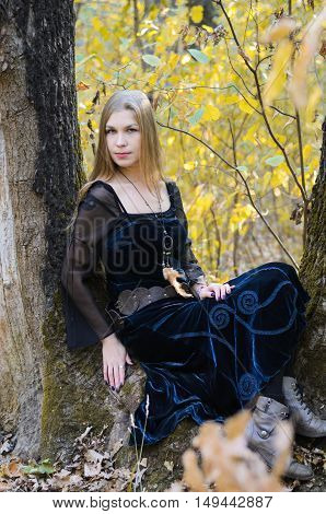 Portrait Of A Young Long-haired Blond Girl In A Black Dress Posing