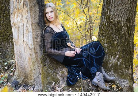 Portrait Of A Young Long-haired Blond Girl In A Black Dress Posing