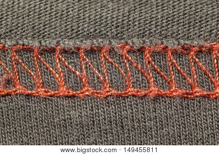 closeup macro red overlock seam on a brown T-shirt fabric