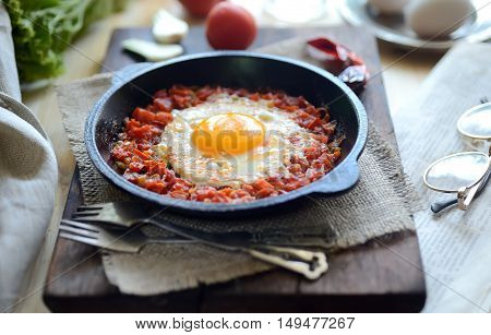 scrambled eggs with fresh tomatoes in a pan. rustic style