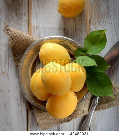 fresh apricots on the plate on a wooden background