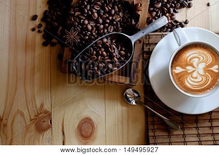 Cup of coffee beans and scoop on old rusty background