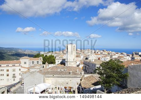 white italian village aerial sea view Monte Sant Angelo Gargano Apulia Italy vivid blue sky cloudscape