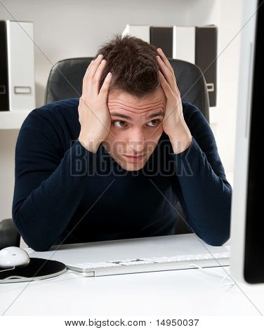 Mladý muž myšlení u počítače