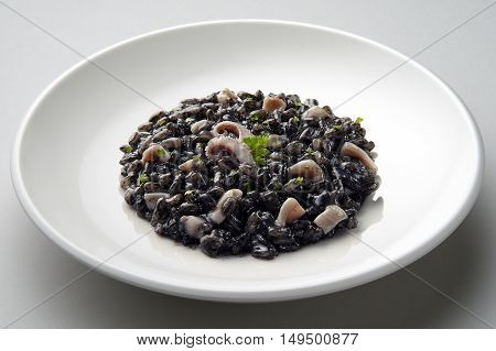 Dish of risotto with squid ink isolated on grey plane