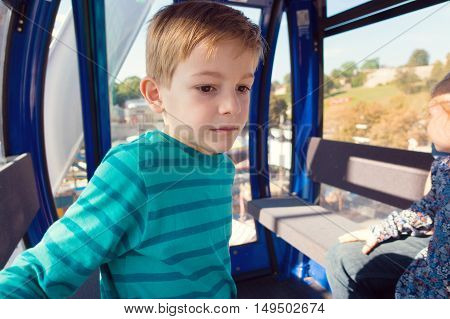 Cute Little Boy Sitting In Ferris Wheel Cabin At Oktoberfest