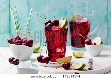 Cherry cola, limeade, lemonade, cocktail in a tall glass on a white, turquoise background Copy space