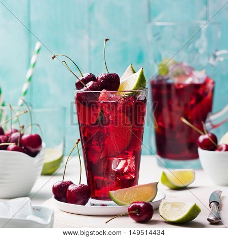 Cherry cola, limeade, lemonade, cocktail in a tall glass on a white, turquoise background Copy space
