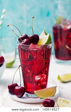 Cherry cola, limeade, lemonade, cocktail in a tall glass on a white, turquoise background Copy space