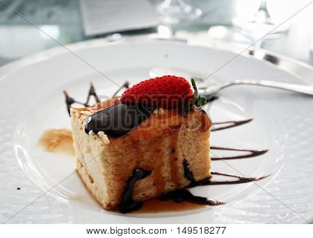 Delicious desert with strawberry chocolate and caramel topping on a white plate