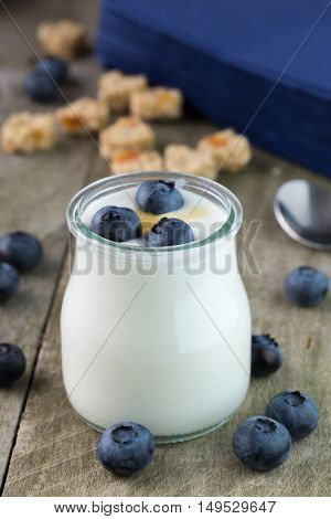 White yogurt in glass jar with honey.