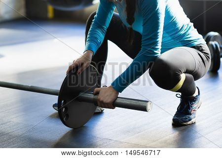 Muscular woman in a gym doing heavy weight exercises. Young woman doing weight lifting at health club.