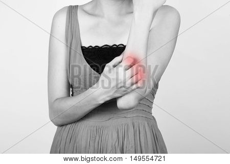 a woman scratching her elbow. health condition
