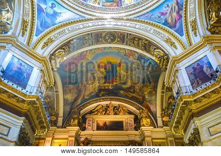 SAINT PETERSBURG RUSSIA - APRIL 25 2015: The splendid rich interior of St Isaac's Cathedral includes painted and mosaic icons covering walls and ceiling surrounded by carved gilt ornaments and old slavonic inscriptions on April 25 in Saint Petersburg.