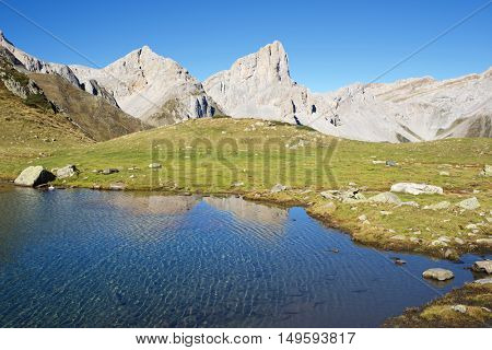 Peaks reflected in Ansabere Lake. Lescun Cirque. Aspe Valley, Pyrenees, France.