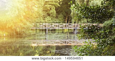 Idillyc nature banner - pond and wooden bridge in a beautiful green forest