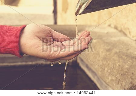Stream of water running over hands closeup.