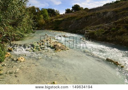 Thermal hot springs with tiny waterfalls in Tuscany Italy.