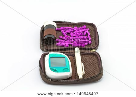 blood glucose meter the blood sugar value is measured on a finger pack in black case on white background.