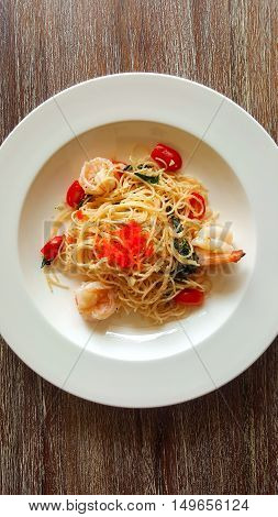 Seafood pasta with Prawns Spaghetti on brown wooden background