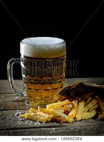fried french fries and beer on a wooden background