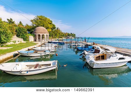 ZADAR CROATIA - SEPTEMBER 14: Harbor with boats and pier in the background where people have come to rlelax and swim on a hot sunny day on September 14th 2016 in Zadar