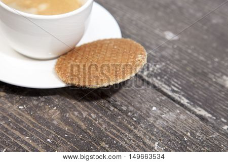 Dutch cookie stroopwafels with cup of coffee on brown wooden background