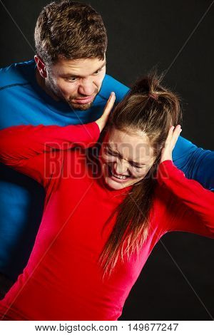 Husband abusing wife. Aggresive man screaming at crying scared woman. Domestic violence aggression.