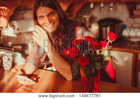 Happy Young Man With Smartphone And Roses.