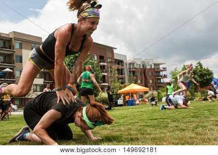 ATLANTA, GA - JULY 2016: Two women play leap frog one of many children's games played by teams at the Atlanta Field Day event at the Old Fourth Ward Park in Atlanta GA on July 16 2016.