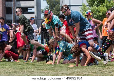 ATLANTA, GA - JULY 2016:  Men and women play leap frog one of many children's games played at the Atlanta Field Day event at the Old Fourth Ward Park in Atlanta GA on July 16 2016.