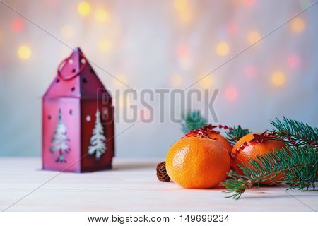 Mandarins with fir-tree branch and house shaped candlestick