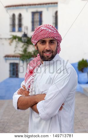 Young smiling handsome arabic man wearing traditional clothes