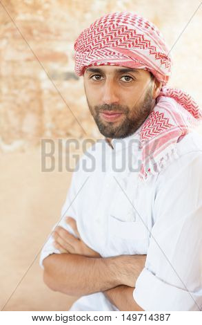 Young smiling handsome arabic man wearing traditional clothes