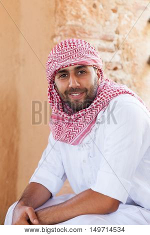 Young smiling handsome arabic man wearing traditional clothes