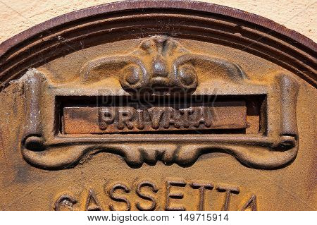 Detail of an Italian old and rusty metal mailbox embedded in a wall with text Privata (Private). Veneto Italy