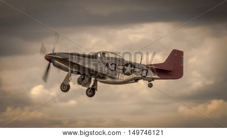 Farnborough, UK - 6th July 2016: A veteran P51 Mustang in flight at twilight after taking off from the airport