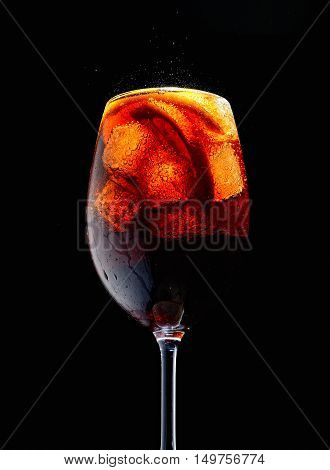 oamy cold Cola in glass on black background