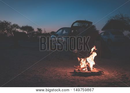 Burning Camp Fire At Dusk In Camping Site, Botswana, Africa. Summer Adventures And Exploration In Th