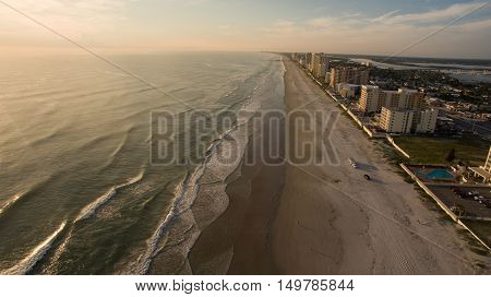 Sunrise in Florida beach with cars riding on the sand