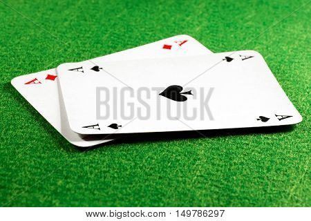 Two aces on green felt casino table ace of spades on top. Selective focus on the spade symbol