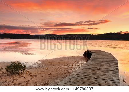 Vibrant Skies And Curved Jetty