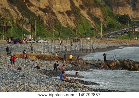 Lima, Peru - December 30, 2013: People on Lima city beach at sunset in Miraflores district