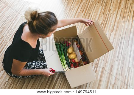 Woman Opening A Vegetable Delivery Box At Home