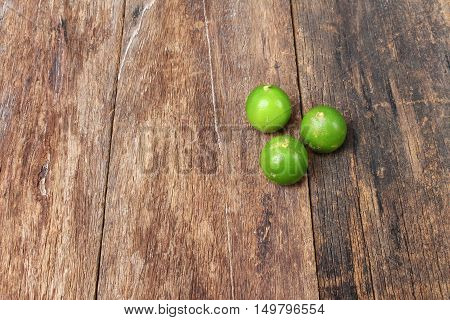 lemon with green on the wooden table top view