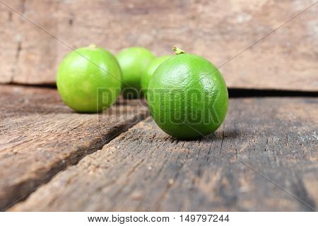 lemon with green closeup Select focus with shallow depth of field on the wooden