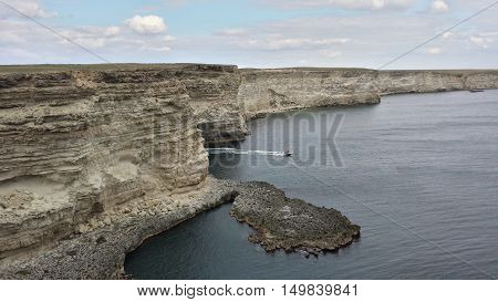 dramatic rocky coastline on the black sea coast with a boat Cape Tarhankut the Crimean Peninsula Russia
